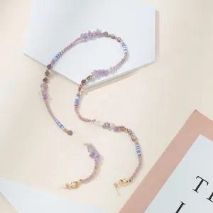 Detail of purple crystal beads and striped stones on eyewear chain with gold lobster clasp