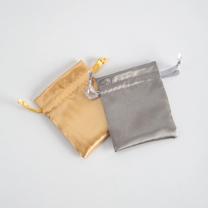 Elegant gold and silver satin drawstring gift pouches for jewelry storage on white background