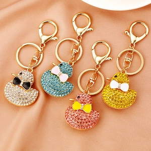 Detailed close-up of crystal duck keychains in silver, blue, pink, and yellow sets