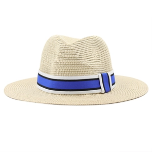 Détail du chapeau de paille beige avec ruban rayé nautique classique sur fond blanc