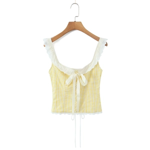 Detail of yellow plaid camisole featuring lace straps and bow tie accents on white background