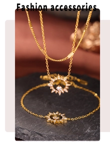 Détail de la parure dorée avec collier et bracelet étoile sertis de zircons sur roche