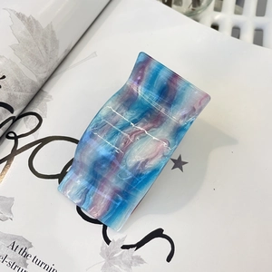 Detail of luxury marble texture acrylic hair claw clip in blue and purple tones