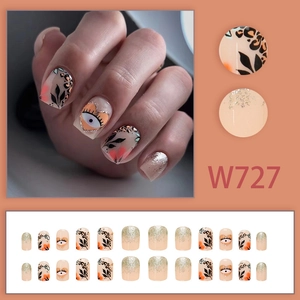 Press-on nail set featuring black leaves, heart evil eyes, and silver glitter patterns