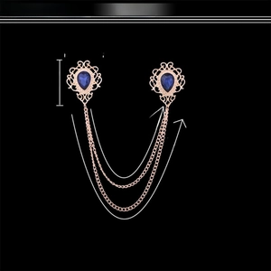 Detailed view of vintage gold tassel brooch with blue teardrop gemstones and chains