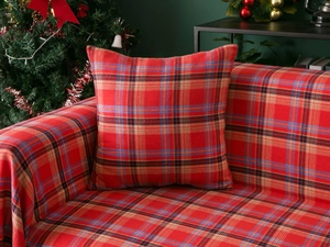 Close-up of red plaid sofa throw and matching pillow with festive Christmas tartan pattern