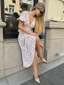 Détail d'une robe fleurie à col en V avec manches bouffantes et motif floral rouge