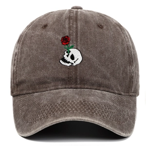 Close-up of vintage skull and red rose embroidery on a washed cotton baseball cap