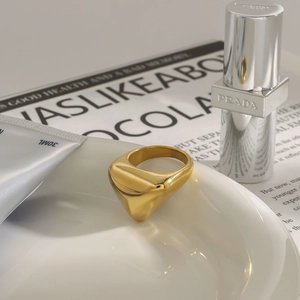Makroaufnahme eines goldenen klobigen geometrischen Schildrings mit Premium-Accessoires