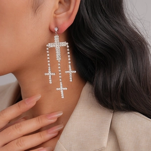 Exaggerated silver cross tassel earrings with rhinestones shown on model in a side view