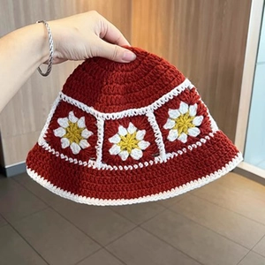 Detailed view of handmade crochet burgundy bucket hat with white and yellow daisy flowers