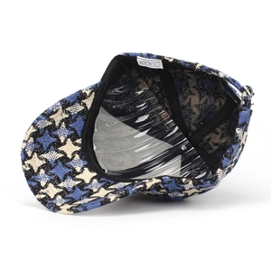 Detail of checkered tweed baseball cap showing interior lining and 100% polyester label