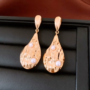 Détail macro de boucles d'oreilles vintage en or 18K avec perles sur cuir noir élégant