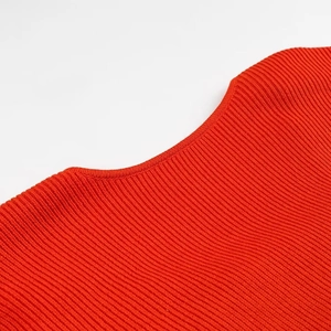 Dettaglio dello scollo del maglione rosso in maglia con trama del tessuto e cuciture