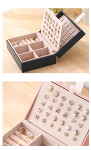 Navy leather jewelry box with velvet lining showing ring slots and necklace hooks