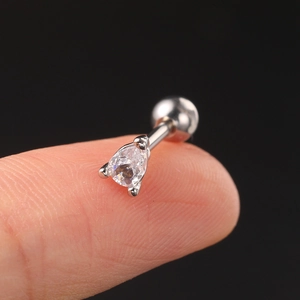 Macro view of teardrop zircon piercing stud on fingertip showing actual small size
