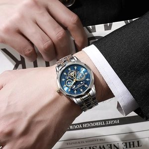 Detailopname van een herenhorloge met blauwe wijzerplaat en roségouden stalen band