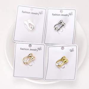 Detailed view of four retro tooth-shaped brooches in gold and silver with rhinestones