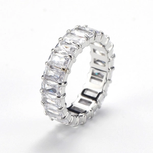 Macro view of emerald-cut clear zircons in a silver claw setting on the ring band
