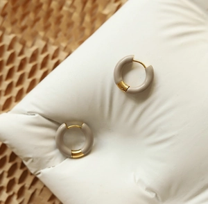 Détail de créoles en émail beige avec charnières en acier inoxydable plaqué or 18 carats