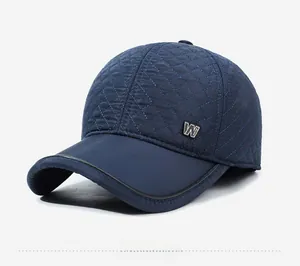 Détail d'une casquette matelassée bleu foncé avec logo W métallique et texture coupe-vent