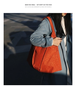 Detail of a bright orange nylon tote bag for women, perfect for daily commuting or casual use