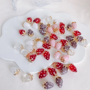 Mix of colorful resin strawberry charms with pearls for DIY earring making on a white plate