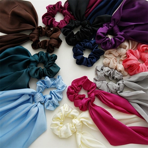 Flat lay of colorful satin hair scrunchies with long ribbons in multiple vibrant colors