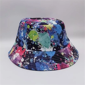 Detail showing vibrant paint splatter graffiti print on a reversible sun bucket hat