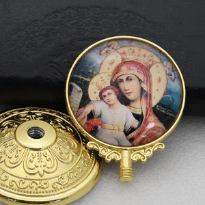 Close-up of golden metal religious icon featuring Virgin and Child with threaded base