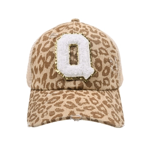 Detail of leopard print baseball cap with glitter Q chenille patch and messy bun mesh back