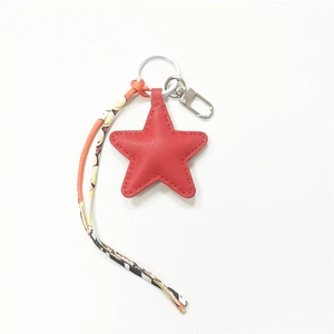 Detailed view of a red star leather keychain with handmade stitching and metal clasp
