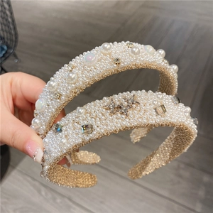 Detail of wide pearl headbands with sparkling rhinestones and metal star accents