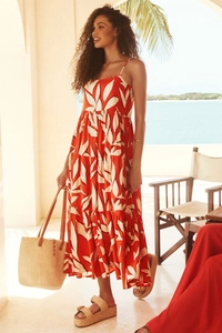 Detail of red leaf print maxi dress with spaghetti straps and pleated tiered hemline