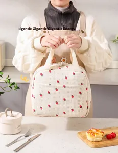 Dettaglio della borsa da pranzo in velluto a coste con fragole e manico in una cucina