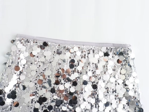 Detail of silver sequin mini skirt showing the waistline finish and shimmering texture