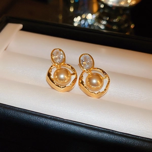 Detail of vintage gold pearl earrings with zircon stones in a jewelry gift box