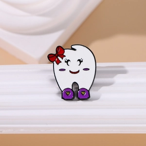 Cartoon tooth enamel pin with a red bow and purple shoes on a minimalist display stand