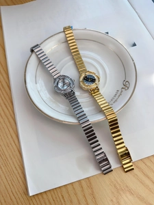 Detail of vintage flower shaped gold and silver quartz watches on a ceramic plate