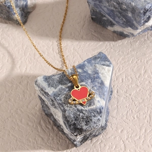 Golden necklace featuring a red heart pendant with a sparkling crystal halo design