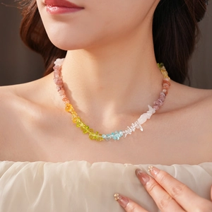 Detail of colorful rainbow natural stone beaded necklace worn on model neck