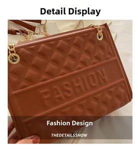 Close-up of embossed FASHION lettering and quilted texture on a brown shoulder bag