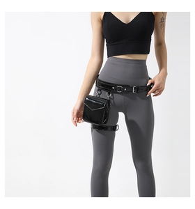 Detail of black PU leather thigh bag with adjustable straps and metal hardware