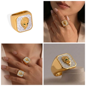 Detailed close-up of 18k gold square lion head ring with green stone eyes and white crystals