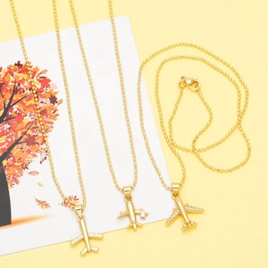 Detailed view of three gold airplane pendants featuring sparkling zircon wings on bead chains