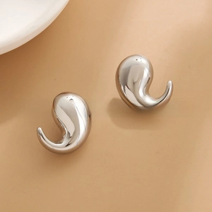 Macro detail of silver teardrop earrings with a smooth polished mirror finish surface