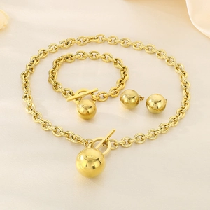 Detailed view of golden jewelry set with sphere pendants and T-bar toggle clasp on silk