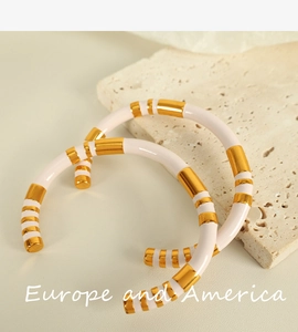 Detail of pink and gold striped enamel stainless steel cuff bracelet on stone base