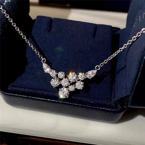 Close-up of elegant V-shaped necklace with pear-cut gemstones in a blue velvet jewelry box