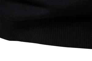 Close-up of the black ribbed cuffs and hem showing high-quality knitted fabric texture